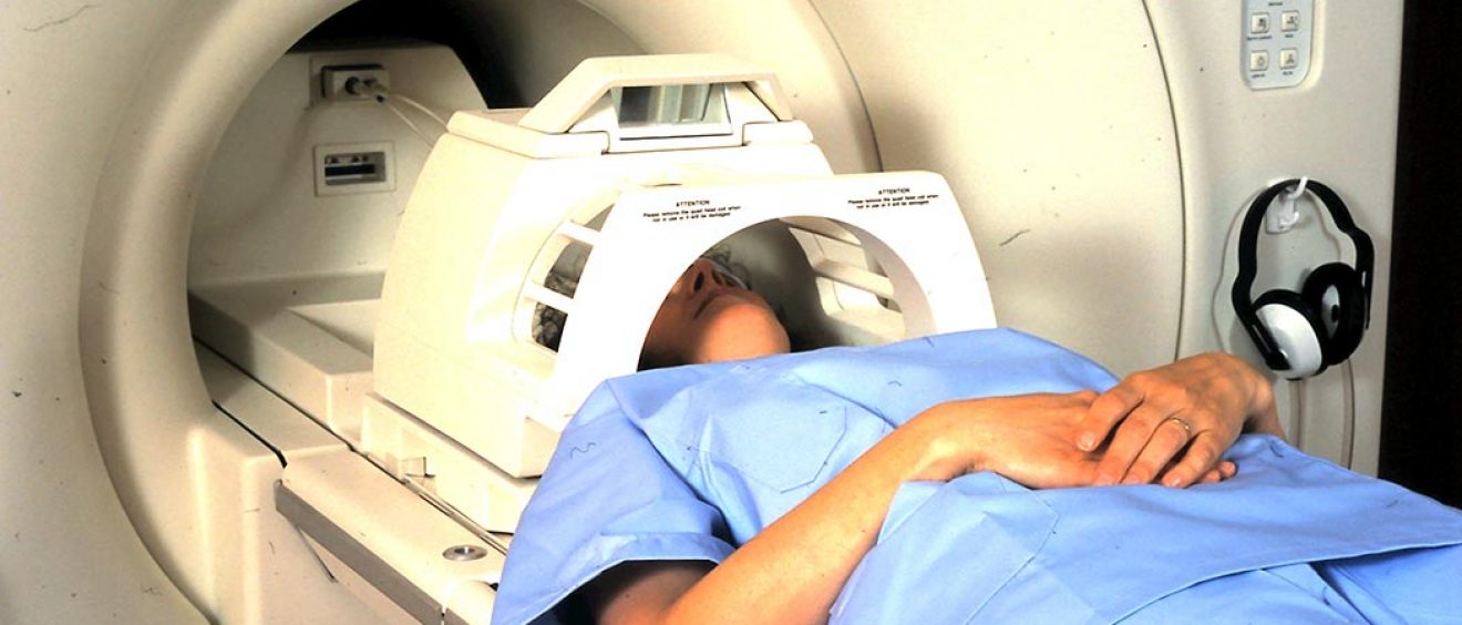patient wearing head guard about to enter scanner