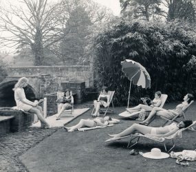 Nurses sunbathe on grass outside Victoria Home
