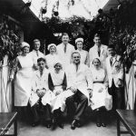 Doctors and nurses pose in corridor decorated with branches