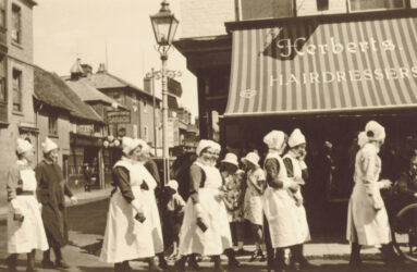 Black and white photograph of nurses in 1920 uniforms in a parade