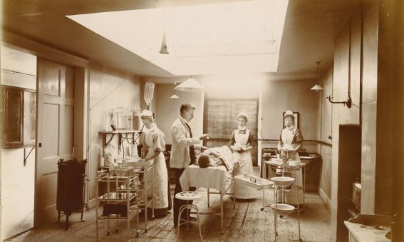 Patient on operating table with lighting, equipment nurses and doctor attending