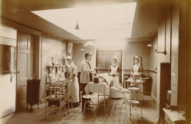 Doctor anaesthetising patient with nurses standing by