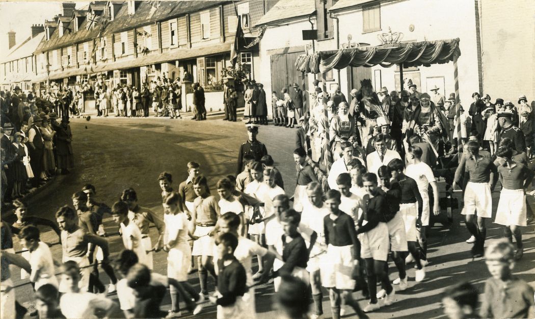 black and white photo of carnival float being pulled by teams of sportsplayers