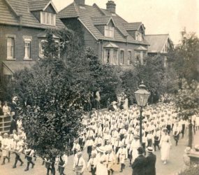 Youth marching in parade dressed in shorts, shirt and tie
