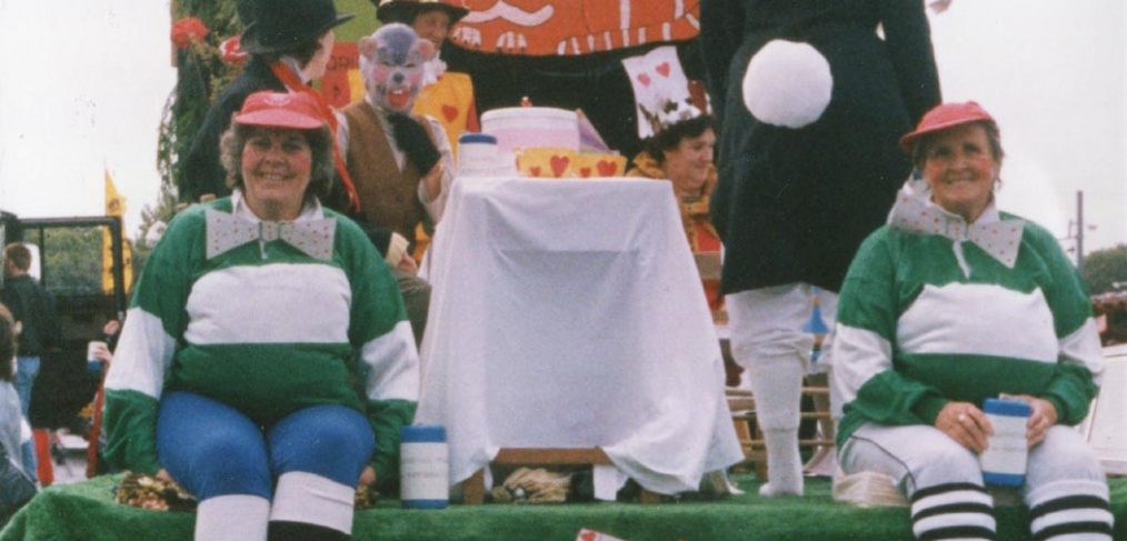 Decorated float with staff dressed as Alice in Wonderland characters
