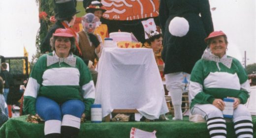 Decorated float with staff dressed as Alice in Wonderland characters