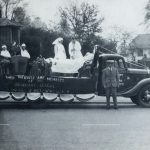 Float with patient in bed and two in chairs being treated by doctor and nurse on the back of truck
