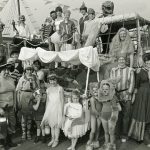 Staff and children dressed as pirates and other characters stand next to float