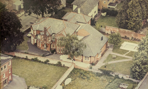 Colour aerial photograph showing large red brick house and town lawns