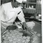 chef cutting out scones from dough and putting on tray