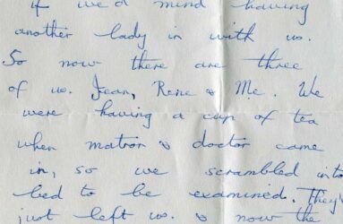 Handwritten letter on grey paper with blue biro writing