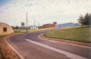 a colour photograph with curved drive and nissen hut