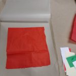 large red square of tissue paper laid inside lamination pouch