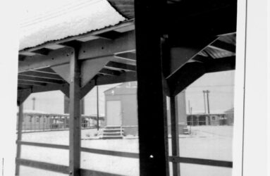 black and white photo of wooden walkways and snow on the ground