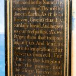 Oak panel arch shape with hand written lettering of Lord's prayer