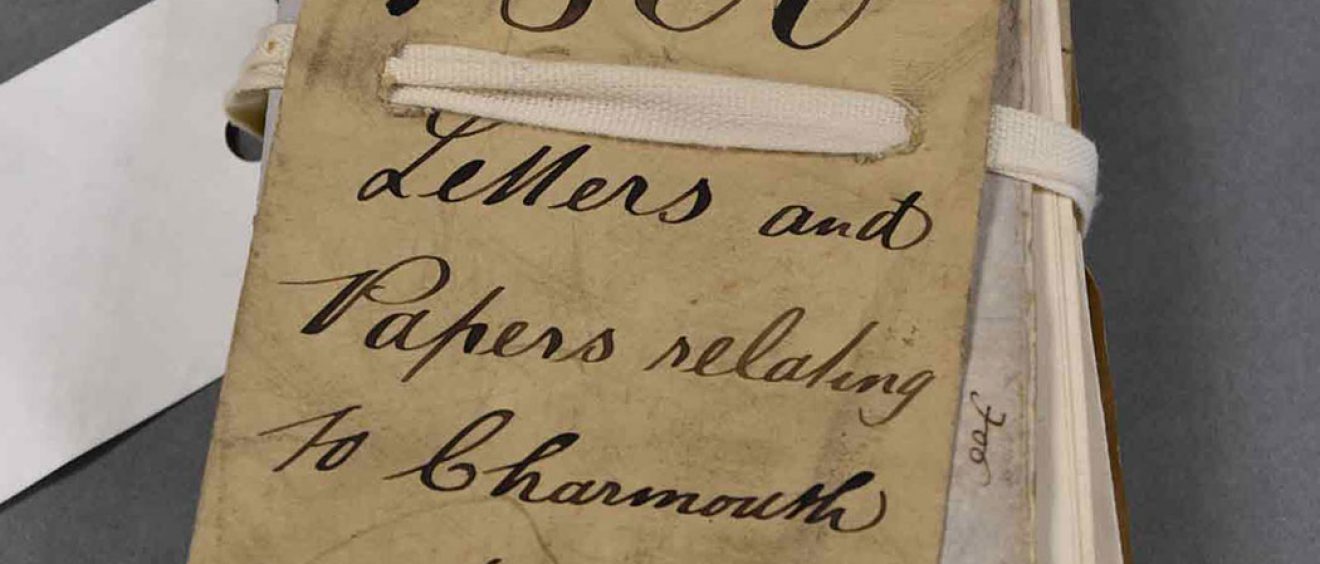 Bundle of old folded papers tied with cord and handwritten label saying 1860