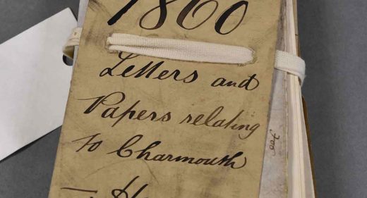 Bundle of old folded papers tied with cord and handwritten label saying 1860