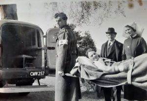 Gordon Richards being carried on stretcher towards back of ambulance