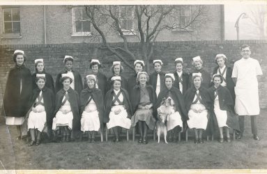 Student nurses pose for photo in uniform with capes