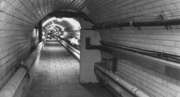 tiled tunnel with pipework visible