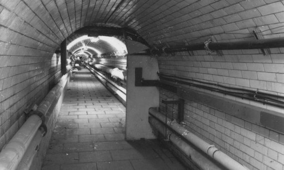 tiled tunnel with pipework visible