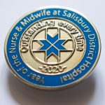 blue enamel badge with florence cross design and 'outstanding every time' inscription